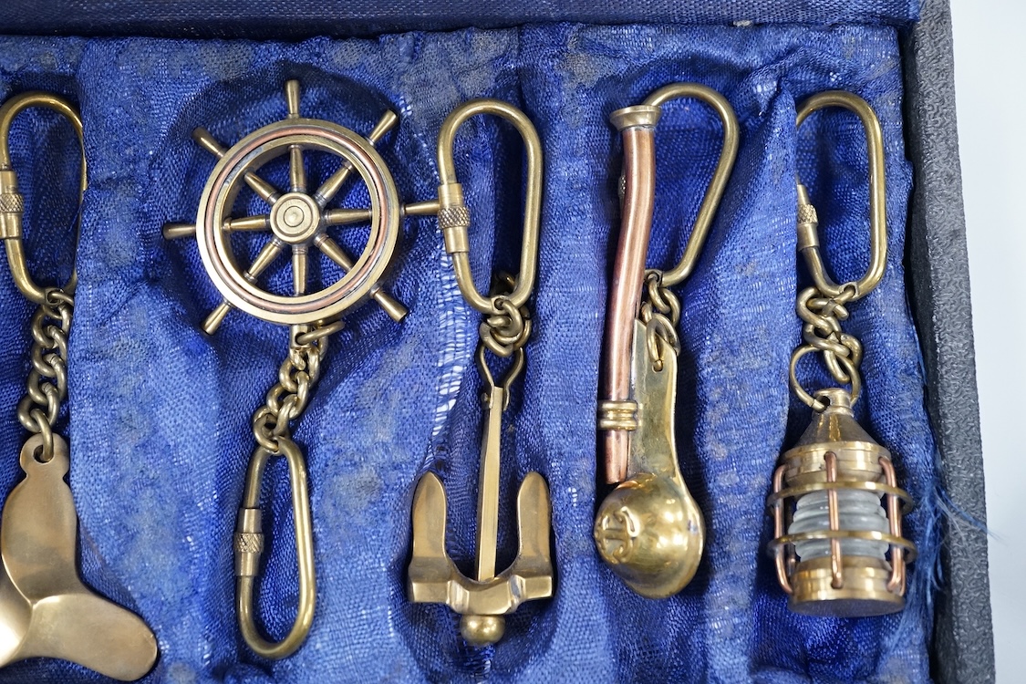 A cased set of enamelled naval buttons and similar keyrings
